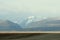 Endless autumn steppe and high snow-capped mountain peaks in the background