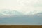 Endless autumn steppe lying at the foot of a mountain range with snow-capped peaks