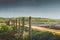 Endless fence of the countryside near the sea. Picturesque colorful landscape against mountains, sky and rural meadow