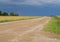 Endless grain fields. Country landscape. Country road in the middle of fields.A thunderstorm is approaching