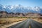 Endless road with snowed mountains in the background.