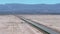 Endless road to horizon through the desert valley. Aerial view of a desert.