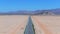 Endless road to horizon through the desert valley. Aerial view of a desert.