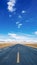 Endless straight road to snow mountains on plain with blue sky and white clouds