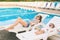 Endless summer! Cute baby and mother relaxing at sunbed