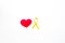 Endometriosis. Gynecological diseases concept. Symbolic yellow ribbon near heart sign on white background top view copy
