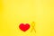 Endometriosis. Gynecological diseases concept. Symbolic yellow ribbon near heart sign on yellow background top view copy
