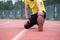 Energetic athlete in activewear and headphones warms up on running track at a city sports ground