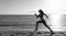 Energetic athletics running woman in activewear run on beach sand along seaside, runner