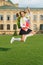 Energetic child in formal uniform with study books backpack jump in schoolyard happy celebrating, back to school