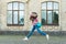 Energetic child girl jumping dancing listening music headphones, happy dance concept