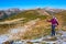 Energetic Female Hiker Walking on Snowy and and Grassy Trail in Scenic Mountain View