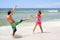 Energetic little children fighting on beach at sea