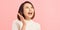 Energetic loud cute beautiful female opening mouth widely, putting hands to mouth, shouting standing  over pink background