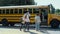 Energetic teen students rushing into school bus. Happy schoolchildren boarding.