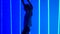 Energetic young woman trains salsa movements. Silhouette of a dancer in the studio against a background of bright blue