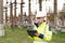 An energy engineer man in special clothes inspects a power line using data from electric sensors on a digital tablet