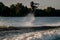 energy man holds rope and and jumping high on splashing wave on a wakeboard