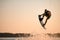 energy muscular sportsman making trick in jump time with wakeboard against the backdrop of the sky