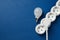 Energy saving bulb and power strip on blue background