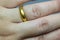 Engagement gold ring on woman`s hand. Detail of one hand with gold ring.