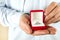 Engagement / marriage / wedding proposal scene. Close up of man handing the expensive gold platinum diamond ring to his bride.