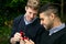 Engagement proposal betwen two gay men as one man proposes with an engagement ring in red box