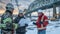 engeneers are discussing bridge construction, one men hold blueprints, wearing uniform and hard hats, in background bridge