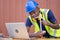 Engineer African American black worker discussing of solar energy from wind turbine model and online with laptop at construction