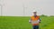 Engineer Analyzing Plan While Looking At Windmills In Farm