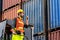Engineer beard man standing with ware a yellow helmet to control loading and check a quality of containers
