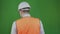 Engineer or builder stands with his back and looks at the construction works. Chromakey. Boss or chief in a white helmet