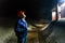 An engineer builds a hydroelectric power station inside a disassembled turbine and shines a flashlight on its walls