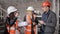 The engineer communicates with the female customer representatives at the construction site, checking the drawings with