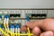 The engineer connects the optical Internet cable with the central router module in the server room of the data center. The front