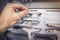 Engineer connects wires to the connector of industrial control controller in electrical cabinet closeup.