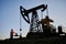 Engineer controlling operation of petroleum rig under blue sky.