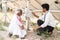 Engineer explaining to Indian farmer about sloar power generation operating below the panel module at agricultural farm