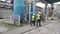 Engineer and foreman doing handshake on factory. Clip. Two workers at the factory in protective helmets