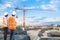 Engineer and foreman looking at crane construction with talking