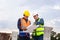 Engineer and foreman worker checking project at building site, Engineer and builders in hardhats discussing blueprint on