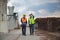 Engineer and foreman worker checking project at building site, Engineer and builders in hardhats discussing blueprint on