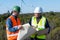 Engineer and geologist consult close to wind turbines in the countryside