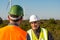 Engineer and geologist consult close to wind turbines in the countryside