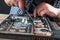 Engineer hands repairs laptop with screwdriver