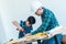 Engineer Handy Father is teaching his boy to use electric driller on wood