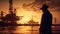 An engineer in a hard hat stands in front of an oil-producing industrial offshore