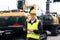 Engineer in a helmet with a digital tablet stands next to construction excavators.