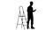 Engineer in a helmet stands near the stepladder. Silhouette. White background. Slow motion