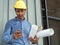 Engineer hold blueprint paper construction drawing plan and holding mobile phone,Architect working in office,Engineering tools on